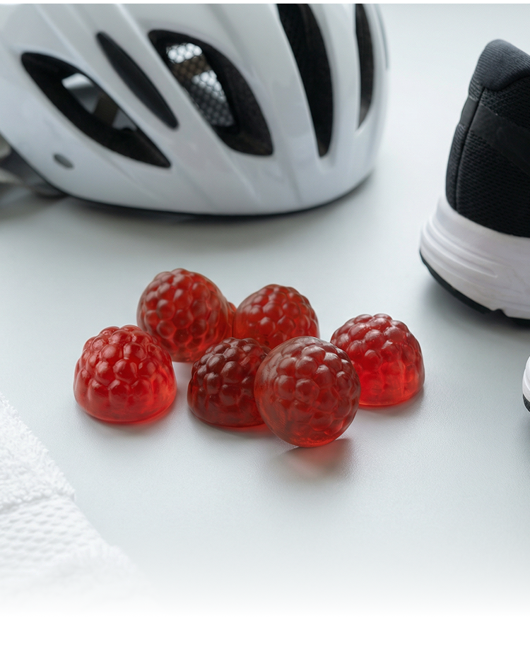 sports gummies next to a cycling helmet and pair of running shoes